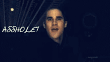 a man is standing in front of a sign that says ' asshole '