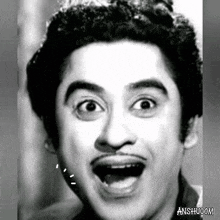 a man with a mustache is making a funny face with his mouth open .