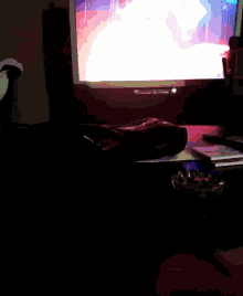 a dark room with a computer monitor and a remote