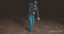 a gif from gifrun.com shows a man dancing in a field at night