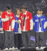 a group of young men are standing on a stage wearing baseball jerseys with the letters bi on them