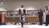 a man in a black jacket with a dragon on the back is standing in front of a crowd