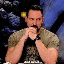 a man sitting at a table with his hands folded and says and sweet