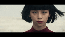 a woman with short black hair and red lips