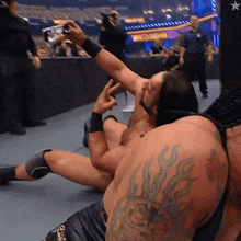 a wrestler with a tattoo on his arm takes a picture