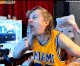 a man in a miami jersey is eating food