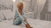 a woman is sitting on a bed with the words i miss you behind her