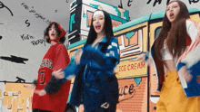 three young women are dancing in front of an ice cream truck