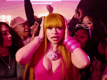 a woman in a pink dress is surrounded by a crowd