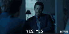 a man in a suit and tie is saying yes