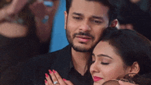 a man is hugging a woman who is wearing a diamond ring on her finger