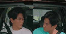two men are sitting in a car and one is wearing a green shirt