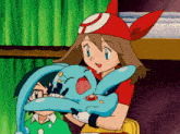 a girl in a red hat is holding a blue toy