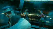 a man wearing sunglasses is standing in a dark room with other people