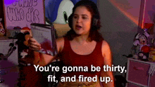 a woman wearing headphones and holding a tablet says you 're gonna be thirty fit and fired up