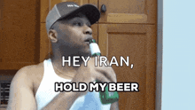 a man drinking from a bottle with the words hey iran hold my beer
