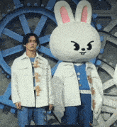 a man standing next to a stuffed bunny mascot