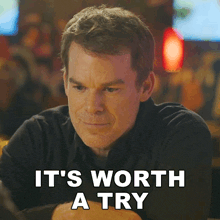 a man sitting at a table with the words it 's worth a try below him