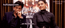 a man and a woman are sitting next to each other and talking .