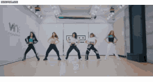 a group of girls are dancing in front of a wall that says wine