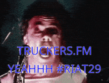 a man singing into a microphone with the words truckers.fm yeahh # riat29 on the bottom
