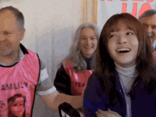 a woman wearing a pink vest with emily on it