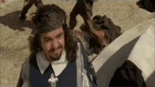 a man with long hair and a beard wearing a headband