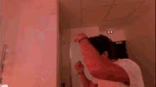a man in a white shirt is looking at himself in the mirror