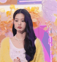 a woman with purple hair is wearing a yellow sweater and a white top