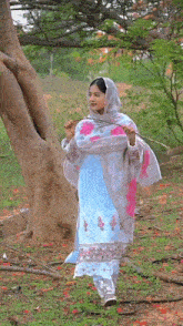 a woman in a blue and white dress holds a stick in her hand