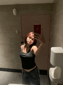 a woman is taking a selfie in a bathroom with an apple phone