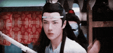a man with a crown on his head looks at the camera