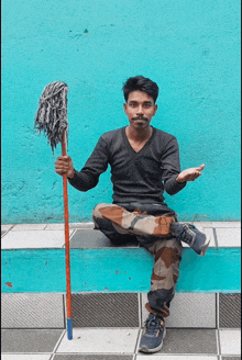 a man sitting on a blue bench holding a mop