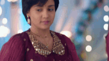 a close up of a woman wearing a red dress and a gold necklace .