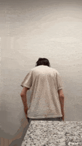 a man wearing headphones is standing in front of a wall with his back to the camera and a tiktok watermark on the bottom