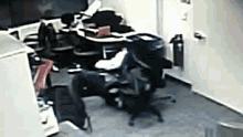 a messy room with a desk and chairs and a trash can on the floor