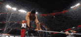 a wrestler in a ring with the letter b on a sign
