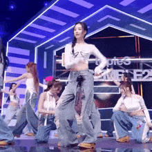 a group of women are dancing on a stage in front of a sign that says types e2