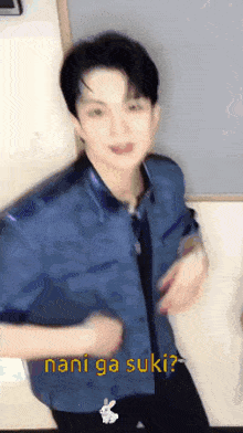 a man in a blue shirt is dancing with the words nani ga suki written on the bottom .