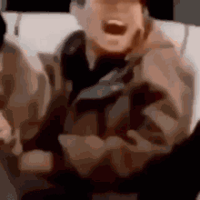 a blurry picture of a man screaming with his mouth open and his arms outstretched .