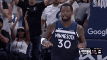 a basketball player wearing a minnesota 30 jersey stands in front of a crowd