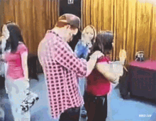 a man in a plaid shirt is touching a woman 's neck