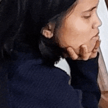 a close up of a woman 's face with her hand on her chin and her eyes closed .