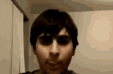 a close up of a man 's face with his eyes closed in a room .