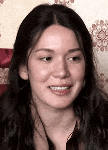 a close up of a woman 's face with a patterned background