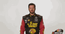 a man in a nascar uniform is waving
