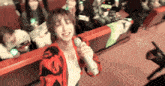 a woman singing into a microphone with a crowd behind her