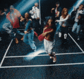 a group of people are dancing in a dark room and one of them has the number 0 on her knee