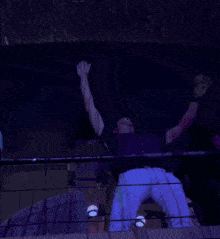 a man is sitting on a balcony with his arm up in the air