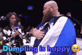 a man with a beard is being interviewed by a woman and the words dumpling is happy are displayed